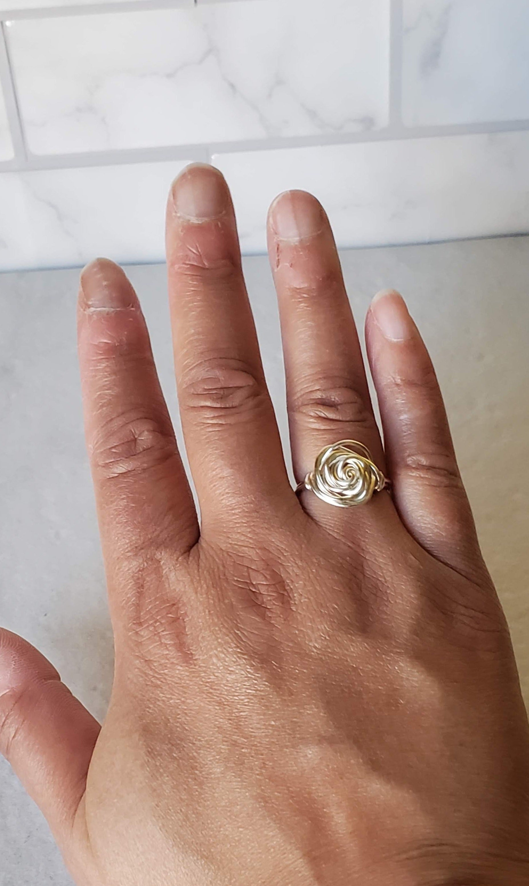 Hand wearing silver rose ring