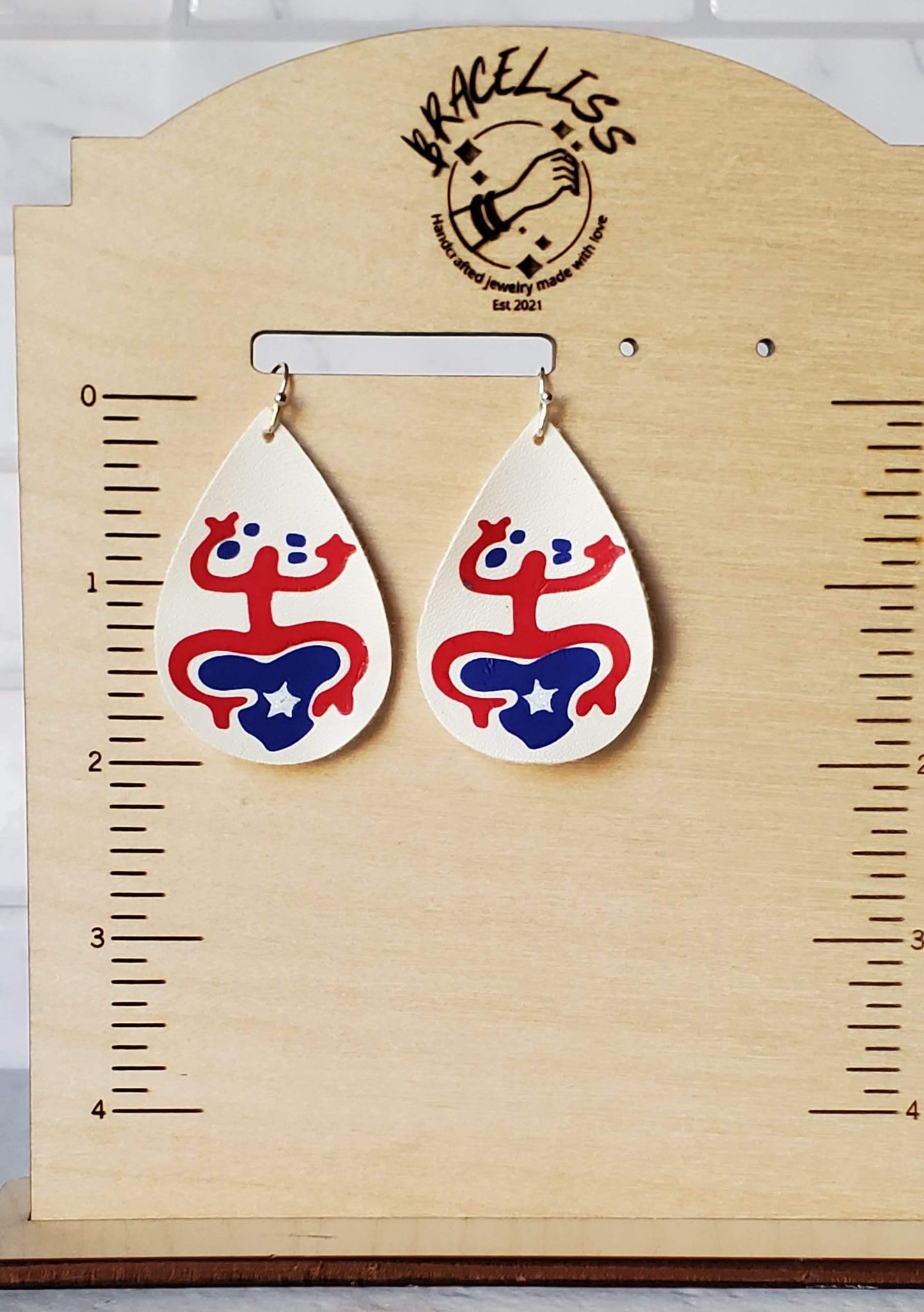 Taino coqui earrings - Cream faux leather earrings on measuring display - braceliss 