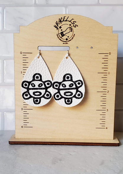 taino sol earrings - white faux leather earrings on measuring display - braceliss
