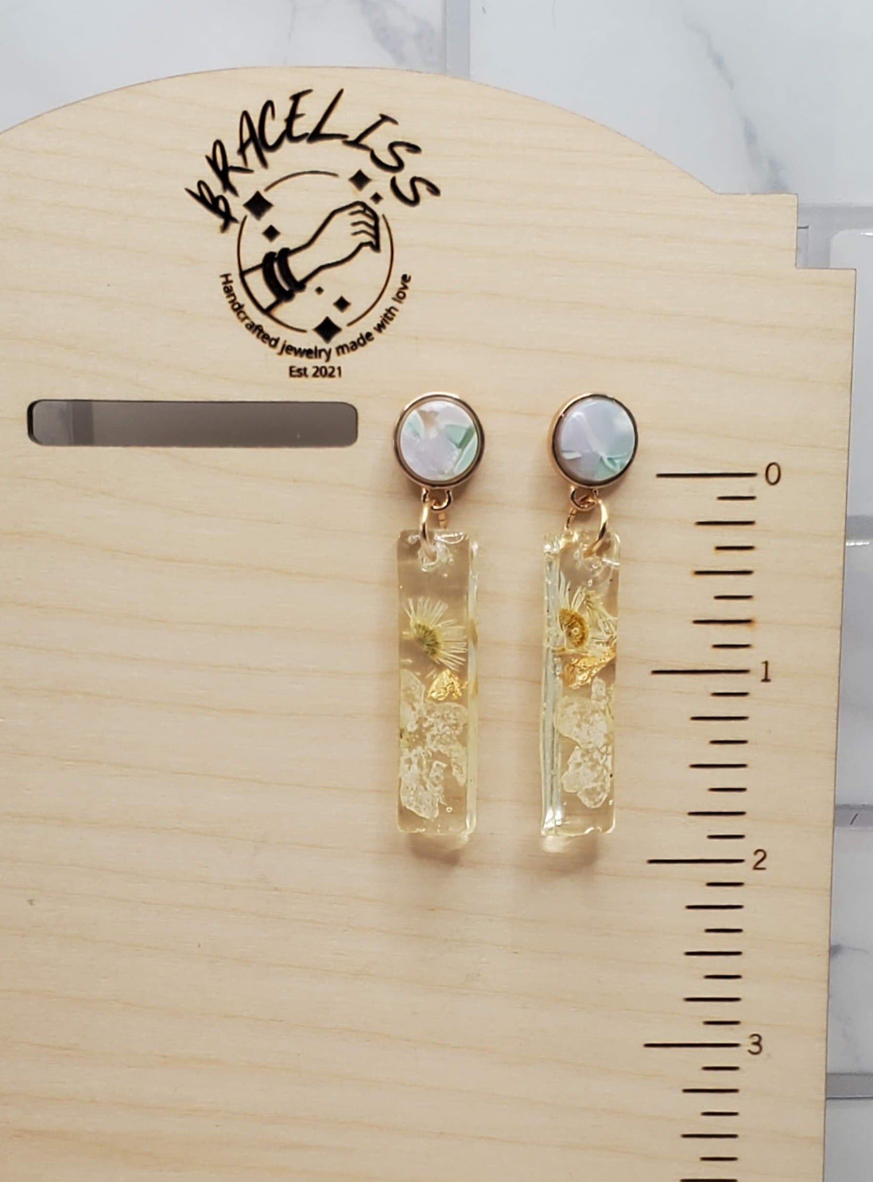 White floral bar earrings - pressed flower resin earrings on display - Braceliss